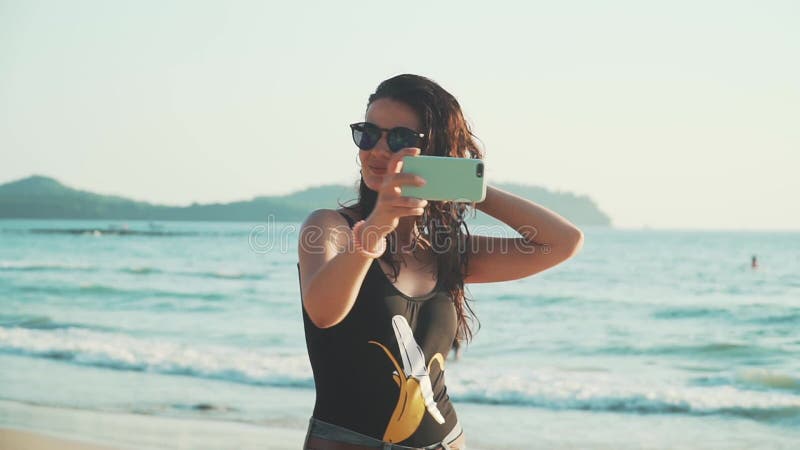 Mujer feliz haciendo selfie en la playa