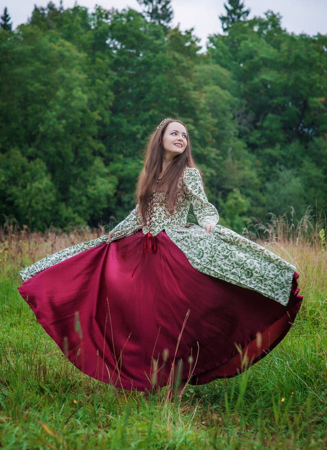 Mujer feliz hermosa en el baile medieval largo del vestido foto de archivo libre de regalías Mujer feliz hermosa en el baile medieval largo del vestido foto de archivo libre de regalías