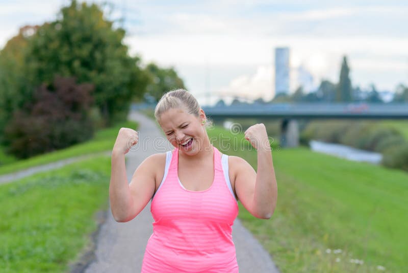 Mujer feliz joven que aumenta las manos mientras que corre imagen de archivo Mujer feliz joven que aumenta las manos mientras que corre imagen de archivo