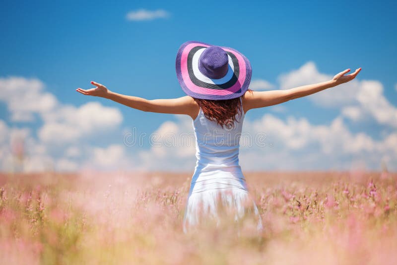 Mujer feliz que disfruta de la vida en el campo con las flores