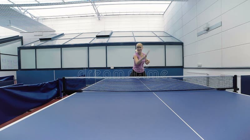 Mujer feliz que juega a los tenis de mesa en la corte almacen de video Mujer feliz que juega a los tenis de mesa en la corte almacen de video
