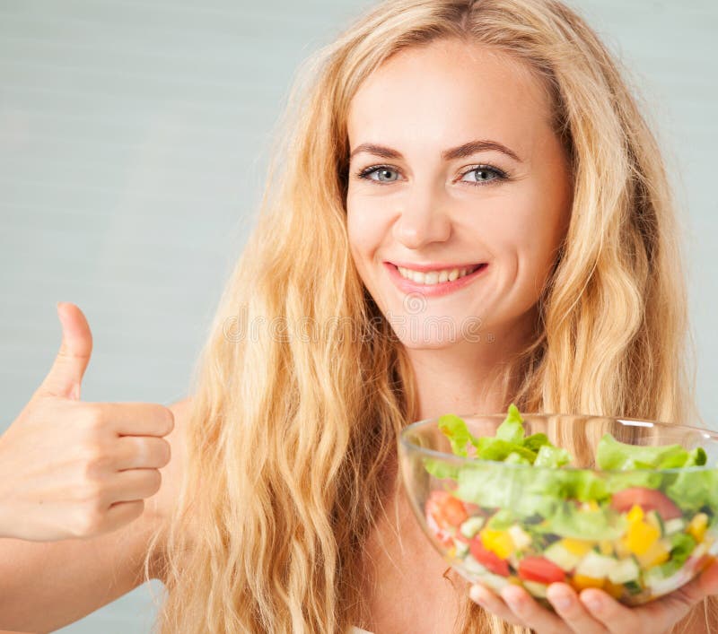 Mujer feliz que prepara la ensalada vegetal imagen de archivo Mujer feliz que prepara la ensalada vegetal imagen de archivo