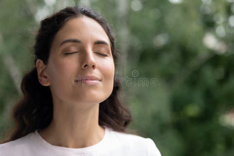 Mujer feliz respira aire fresco soñando con los ojos cerrados