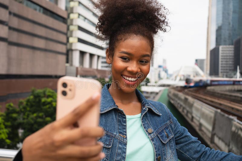 Mujer feliz sonriente caminando en la calle con mochila en la ciudad foto de archivo libre de regalías