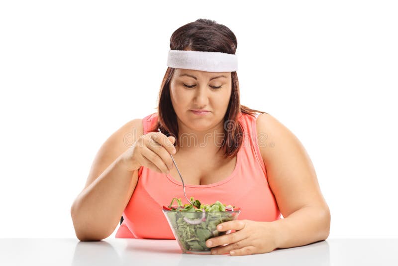 Mujer gorda triste que se sienta en una tabla y que mira un cuenco de imagen de archivo Mujer gorda triste que se sienta en una tabla y que mira un cuenco de imagen de archivo