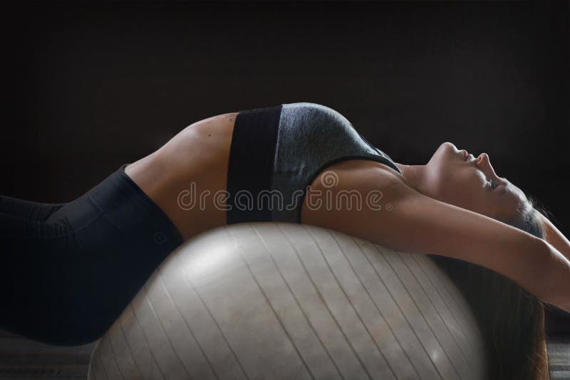 Mujer haciendo ejercicio de sus abetos en una pelota de pilates