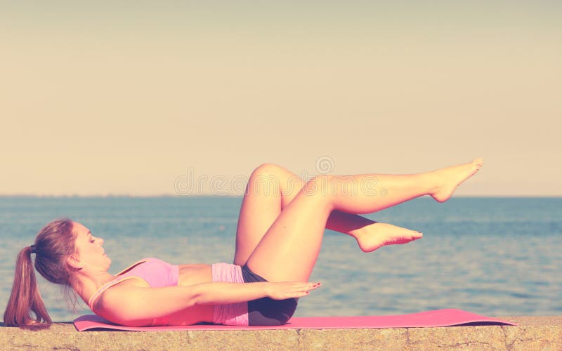 Mujer haciendo ejercicios deportivos al aire libre por mar fotografía de archivo libre de regalías