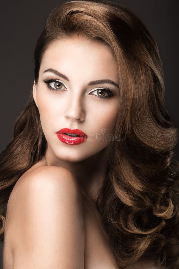 Mujer hermosa con maquillaje de la tarde, labios rojos y rizos Cara de la belleza fotos de archivo Mujer hermosa con maquillaje de la tarde, labios rojos y rizos Cara de la belleza fotos de archivo