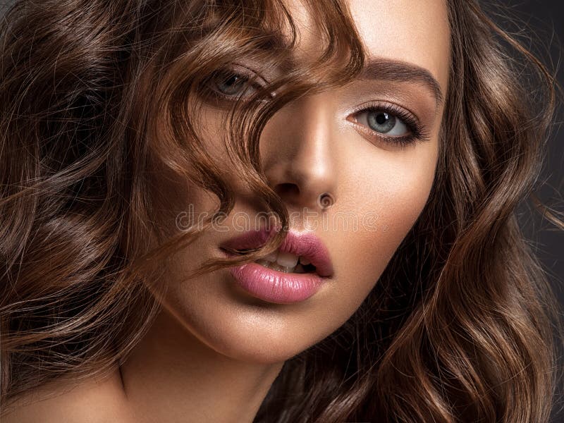 Mujer hermosa con pelo castaño Hermosa cara de un modelo atractivo con maquillaje de moda fotografía de archivo libre de regalías