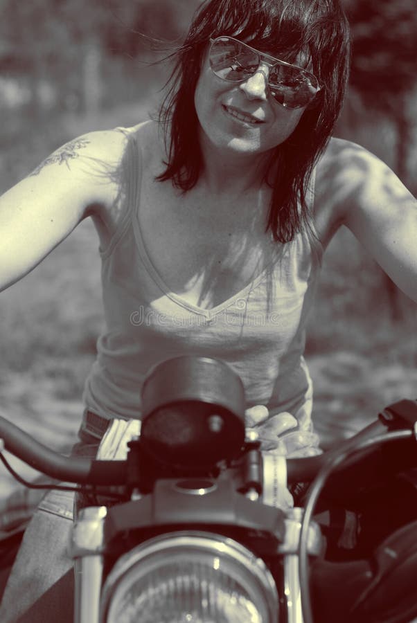 Mujer hermosa con su motocicleta imagen de archivo Mujer hermosa con su motocicleta imagen de archivo