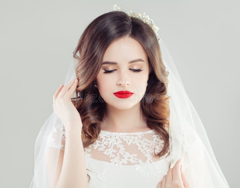 Mujer hermosa de la novia con maquillaje rojo de los labios, pelo nupcial y velo fotos de archivo Mujer hermosa de la novia con maquillaje rojo de los labios, pelo nupcial y velo fotos de archivo