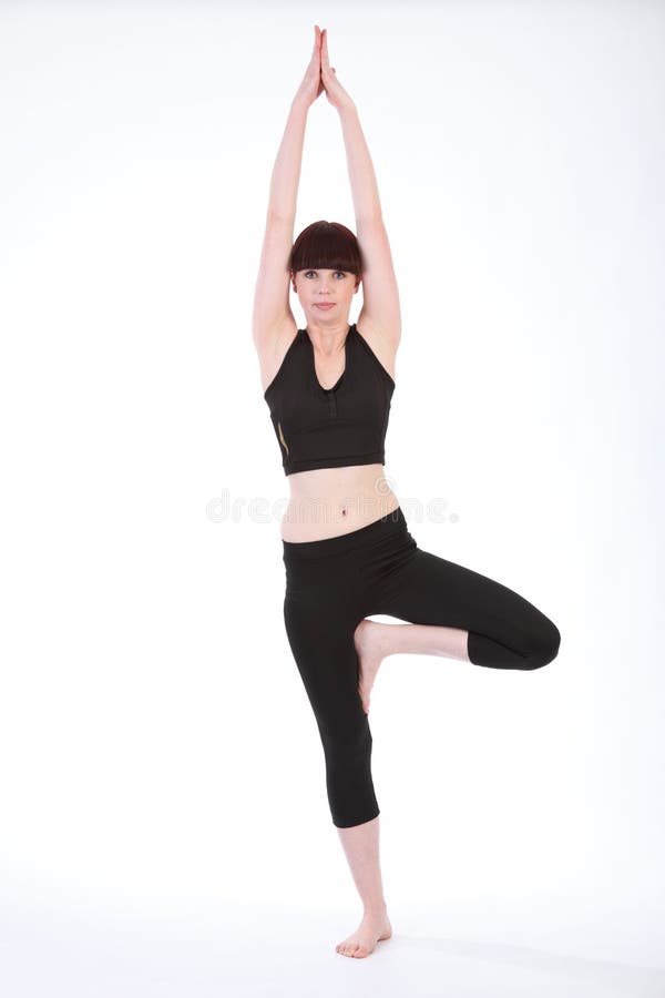 Mujer hermosa del ajuste en la actitud Vrksasana del árbol de la yoga imagen de archivo Mujer hermosa del ajuste en la actitud Vrksasana del árbol de la yoga imagen de archivo