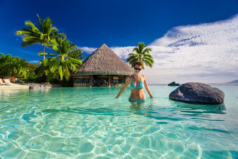 Mujer hermosa en bikini azul dentro de la piscina tropical del infinito, TA fotografía de archivo Mujer hermosa en bikini azul dentro de la piscina tropical del infinito, TA fotografía de archivo