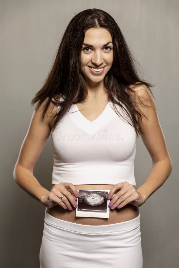 Mujer hermosa en embarazo temprano con resultado del ultrasonido fotos de archivo Mujer hermosa en embarazo temprano con resultado del ultrasonido fotos de archivo