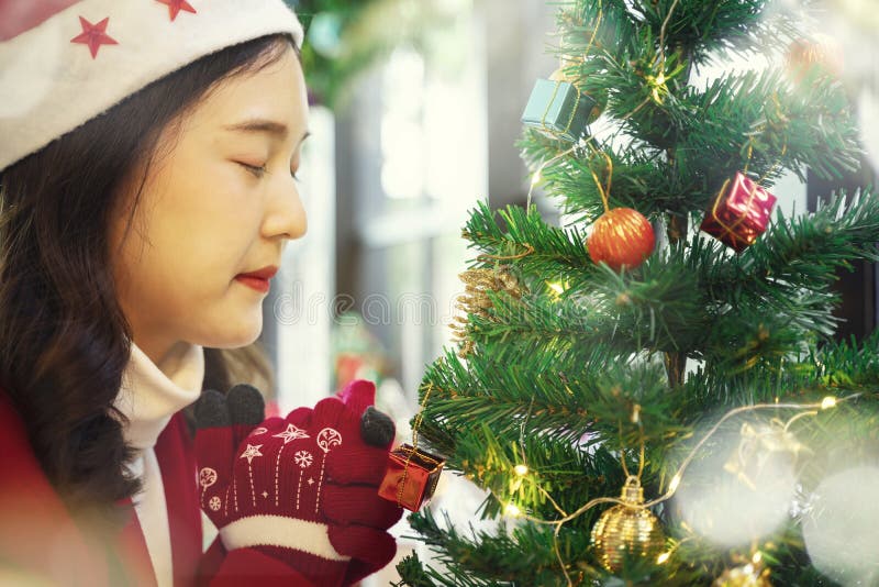 Mujer hermosa en ropa roja que ruega en noche de la Navidad con el árbol de navidad y los accesorios adornados foto de archivo libre de regalías Mujer hermosa en ropa roja que ruega en noche de la Navidad con el árbol de navidad y los accesorios adornados foto de archivo libre de regalías