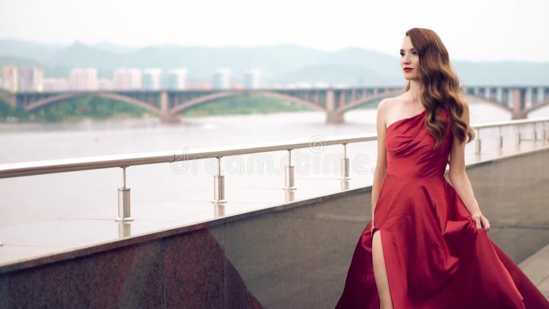 Mujer hermosa en vestido que agita rojo