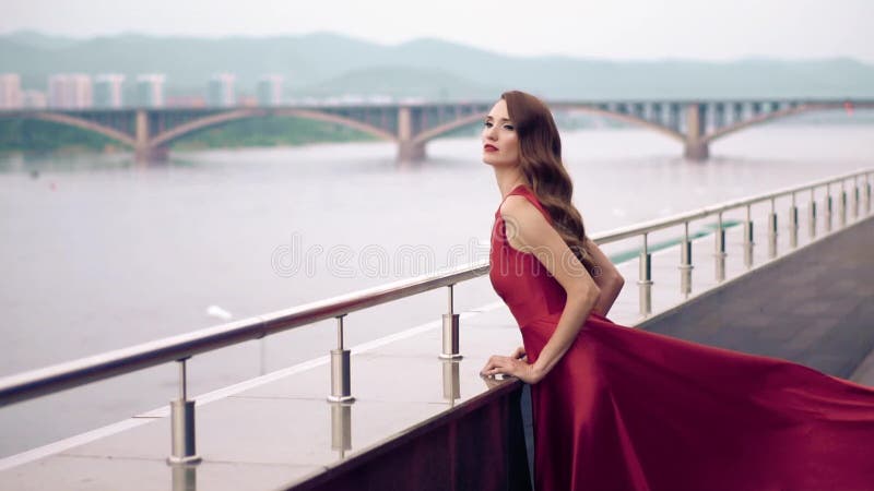 Mujer hermosa en vestido que agita rojo