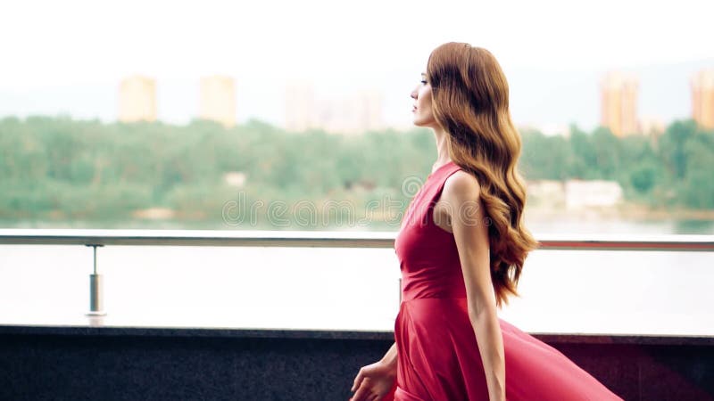 Mujer hermosa en vestido que agita rojo