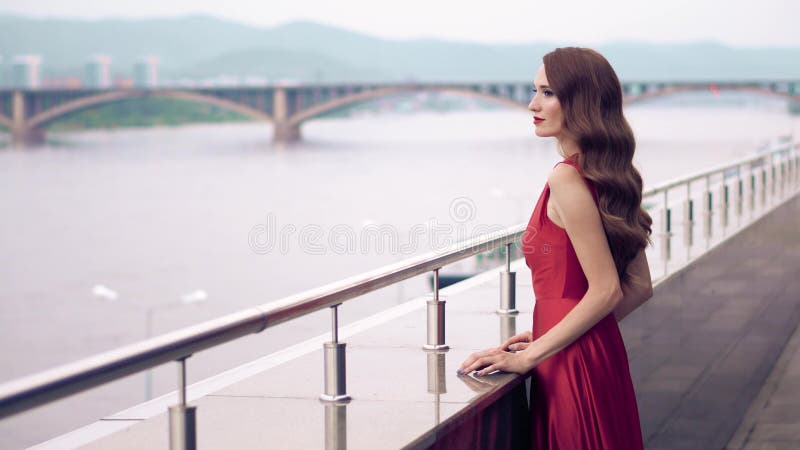 Mujer hermosa en vestido que agita rojo