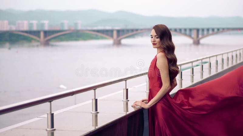 Mujer hermosa en vestido que agita rojo