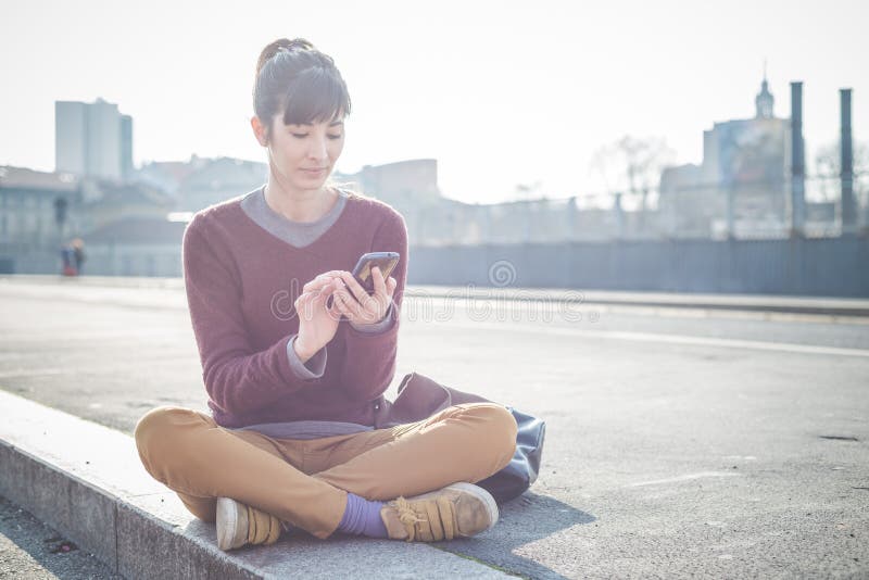 Mujer hermosa joven del inconformista que usa el teléfono elegante imagen de archivo Mujer hermosa joven del inconformista que usa el teléfono elegante imagen de archivo