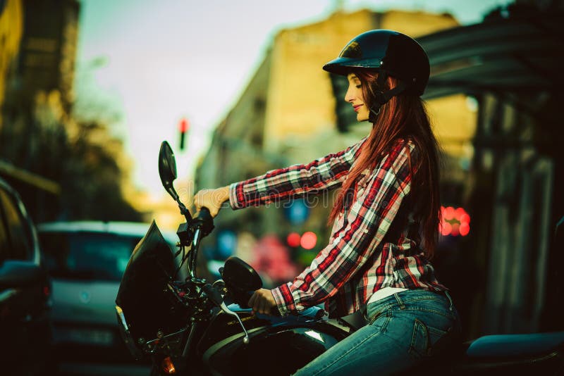 Mujer hermosa joven en la motocicleta fotografía de archivo Mujer hermosa joven en la motocicleta fotografía de archivo