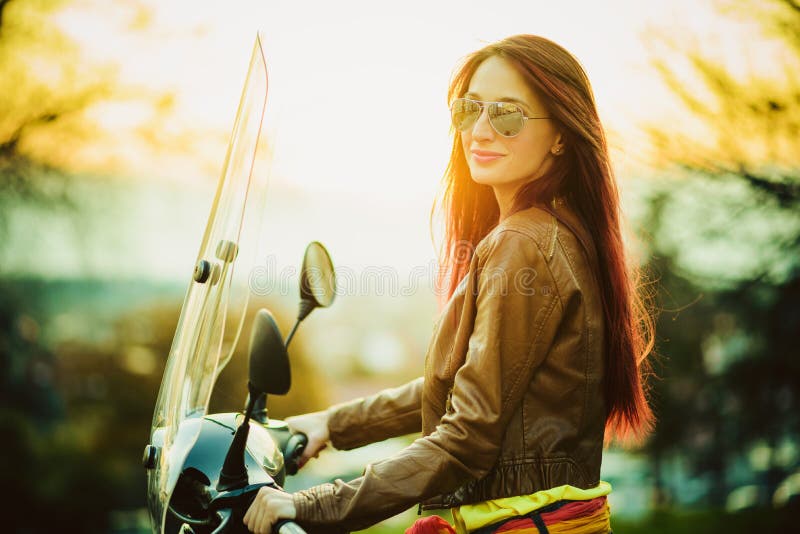 Mujer hermosa joven en la motocicleta foto de archivo Mujer hermosa joven en la motocicleta foto de archivo