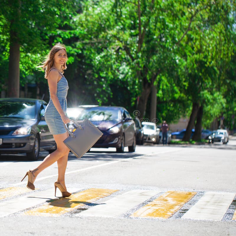Mujer hermosa joven en un vestido corto azul que camina en el camino fotografía de archivo libre de regalías Mujer hermosa joven en un vestido corto azul que camina en el camino fotografía de archivo libre de regalías
