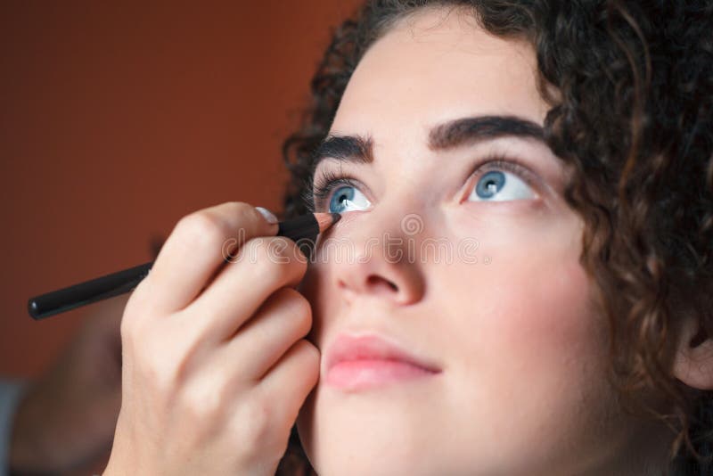 Mujer hermosa joven que aplica lápiz de ojos en el párpado con el lápiz imagen de archivo Mujer hermosa joven que aplica lápiz de ojos en el párpado con el lápiz imagen de archivo