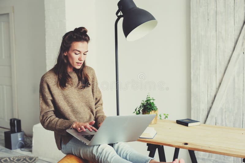 Mujer hermosa joven que hace compras en casa en línea con el ordenador portátil y la taza de café por la mañana imagen de archivo libre de regalías Mujer hermosa joven que hace compras en casa en línea con el ordenador portátil y la taza de café por la mañana imagen de archivo libre de regalías