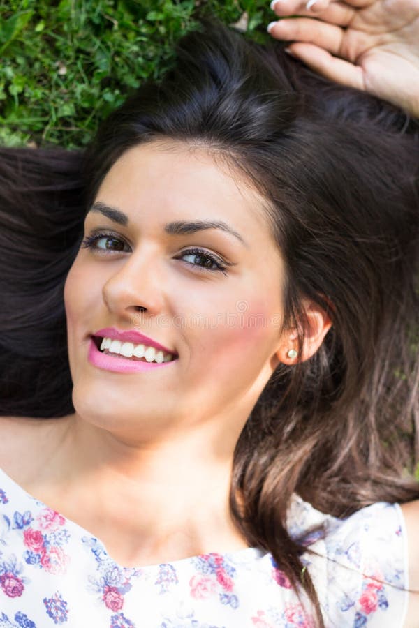 Mujer hermosa joven que miente en hierba foto de archivo Mujer hermosa joven que miente en hierba foto de archivo
