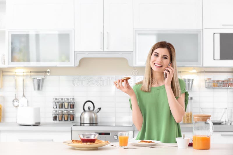 Mujer hermosa que come el pan tostado sabroso con el atasco fotos de archivo Mujer hermosa que come el pan tostado sabroso con el atasco fotos de archivo