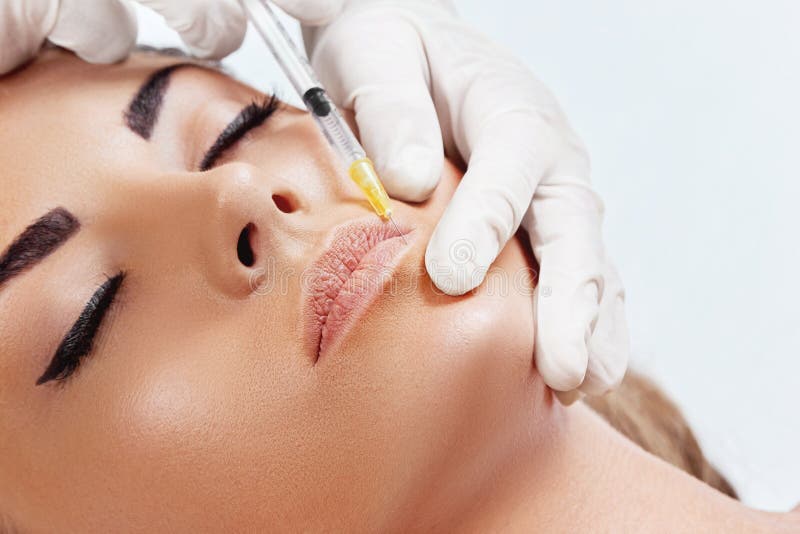 Mujer hermosa que consigue la inyección cosmética del botox en labios, cirugía plástica, concepto de la belleza fotografía de archivo Mujer hermosa que consigue la inyección cosmética del botox en labios, cirugía plástica, concepto de la belleza fotografía de archivo
