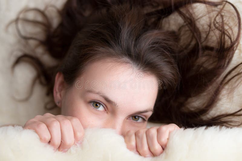 Mujer hermosa que miente en cama y que mira la cámara fotos de archivo libres de regalías Mujer hermosa que miente en cama y que mira la cámara fotos de archivo libres de regalías