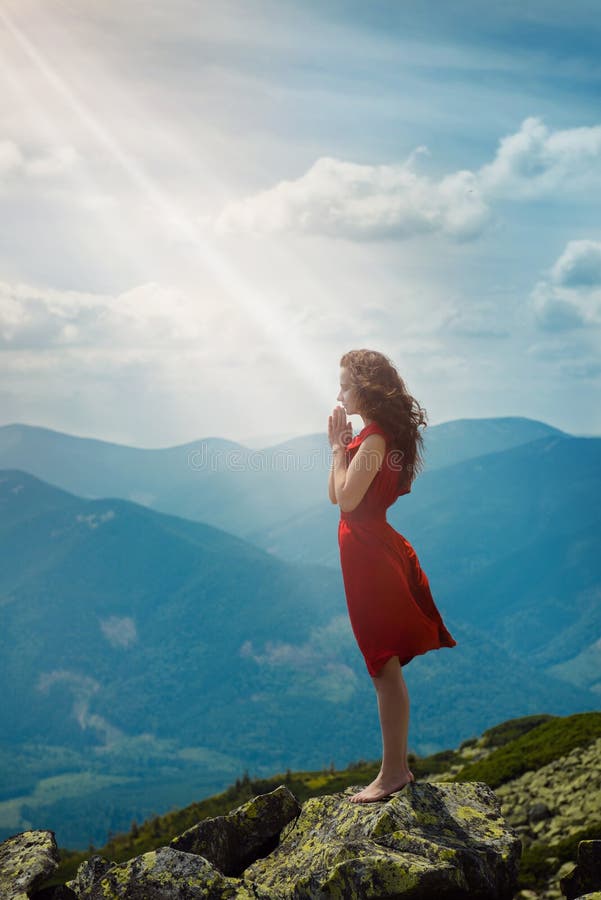 Mujer hermosa que ruega en paisaje de la montaña fotos de archivo libres de regalías Mujer hermosa que ruega en paisaje de la montaña fotos de archivo libres de regalías