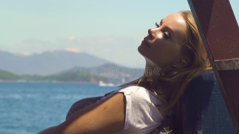 Mujer hermosa que se relaja en velero en paisaje del mar Mujer joven que disfruta de la navegación a bordo de la nave del mar Océ almacen de video