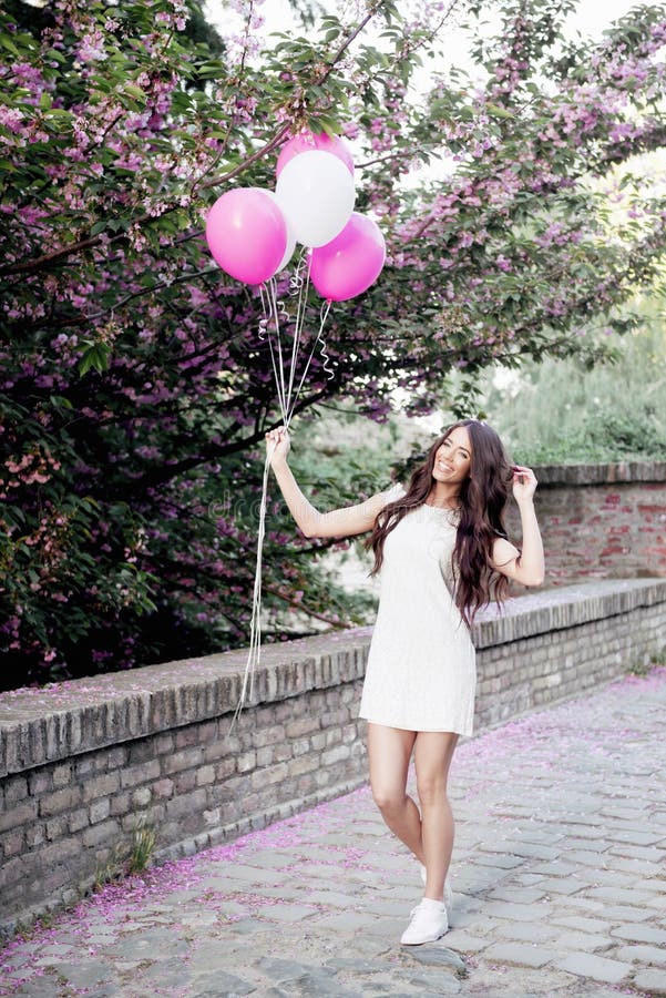 Mujer hermosa que sostiene los globos al aire libre foto de archivo Mujer hermosa que sostiene los globos al aire libre foto de archivo