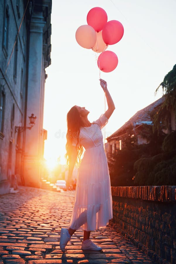Mujer hermosa que sostiene los globos al aire libre imagen de archivo libre de regalías Mujer hermosa que sostiene los globos al aire libre imagen de archivo libre de regalías