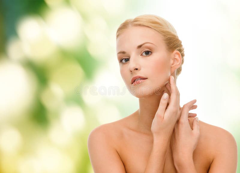 Beauty and spa concept - face of beautiful woman touching her face skin. Beauty and spa concept - face of beautiful woman touching her face skin