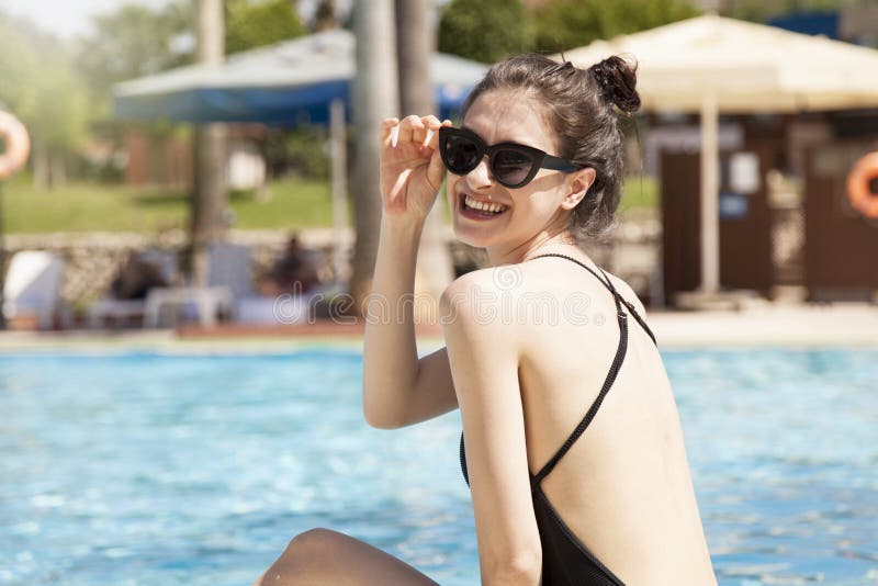 Mujer hermosa que toma el sol por la piscina Concepto del verano fotografía de archivo libre de regalías Mujer hermosa que toma el sol por la piscina Concepto del verano fotografía de archivo libre de regalías