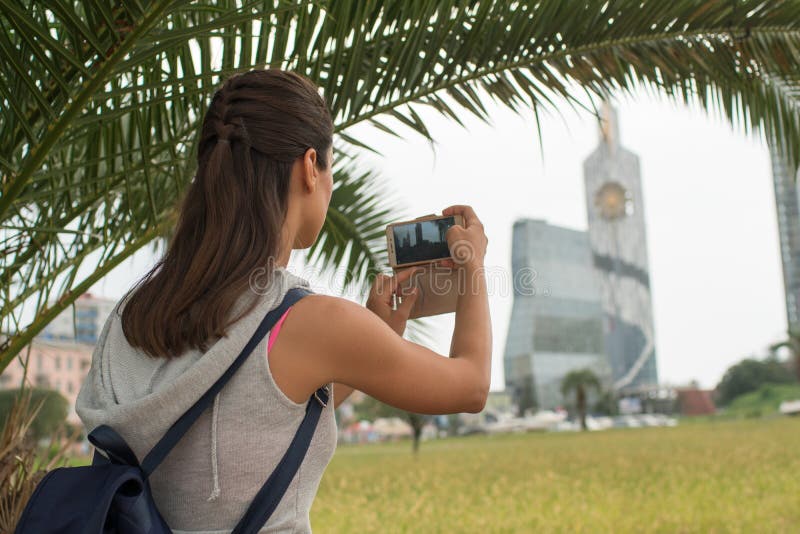Mujer hermosa que toma imágenes de las hermosas vistas de la ciudad foto de archivo libre de regalías Mujer hermosa que toma imágenes de las hermosas vistas de la ciudad foto de archivo libre de regalías