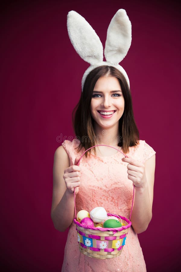 Mujer hermosa sonriente con una cesta del huevo de Pascua fotos de archivo libres de regalías Mujer hermosa sonriente con una cesta del huevo de Pascua fotos de archivo libres de regalías