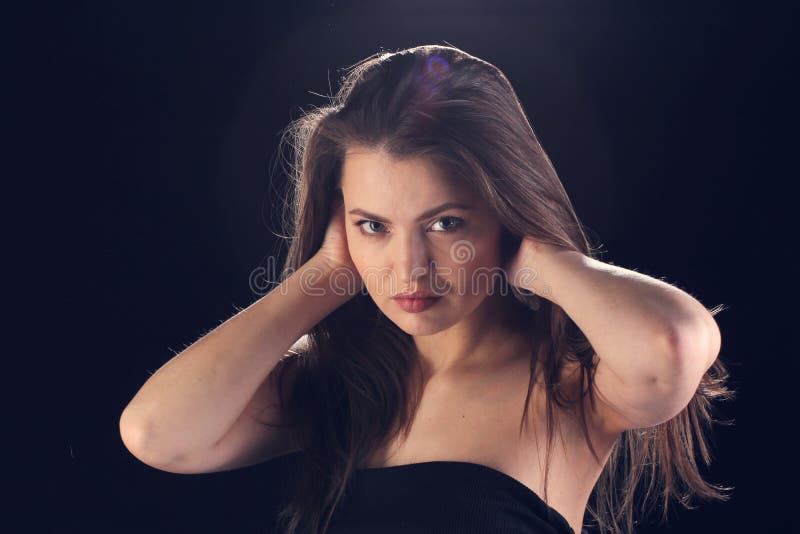 Mujer iluminada por la luz de la etapa foto de archivo libre de regalías Mujer iluminada por la luz de la etapa foto de archivo libre de regalías