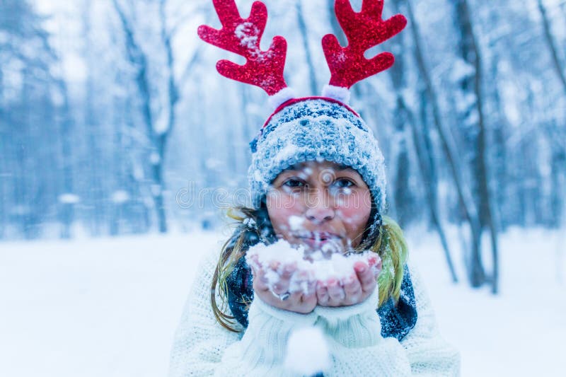 Mujer india feliz divirtiéndose y disfrutando de la primera nieve usando divertido sombrero cuerno de ciervo imagen de archivo libre de regalías
