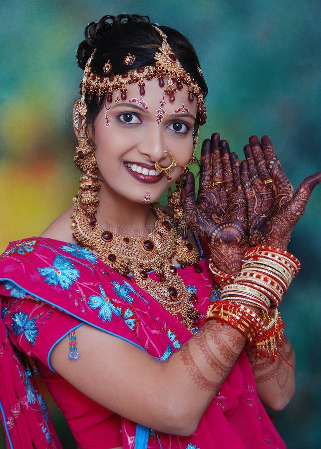 Formal portrait of an Indian woman in traditional dress with ornate jewelery and mehndi decoration or henna tattoos. Formal portrait of an Indian woman in traditional dress with ornate jewelery and mehndi decoration or henna tattoos.