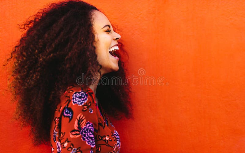 Mujer joven africana de risa con el pelo rizado fotografía de archivo Mujer joven africana de risa con el pelo rizado fotografía de archivo