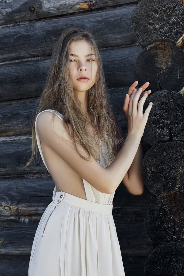 Mujer joven atractiva en un vestido blanco ligero que presenta en el pueblo cerca de la casa vieja Muchacha con una figura perfec imagen de archivo libre de regalías Mujer joven atractiva en un vestido blanco ligero que presenta en el pueblo cerca de la casa vieja Muchacha con una figura perfec imagen de archivo libre de regalías