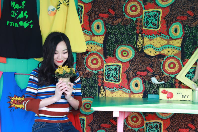 Mujer joven china asiática hermosa que se relaja en una silla fotografía de archivo libre de regalías Mujer joven china asiática hermosa que se relaja en una silla fotografía de archivo libre de regalías