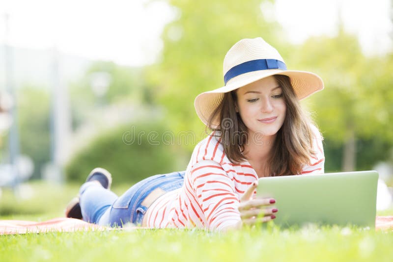 Mujer joven con la computadora portátil al aire libre fotos de archivo libres de regalías Mujer joven con la computadora portátil al aire libre fotos de archivo libres de regalías