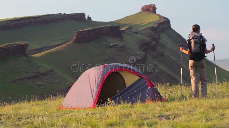 Mujer joven con la naturaleza al aire libre del staysin de la mochila durante día soleado del verano